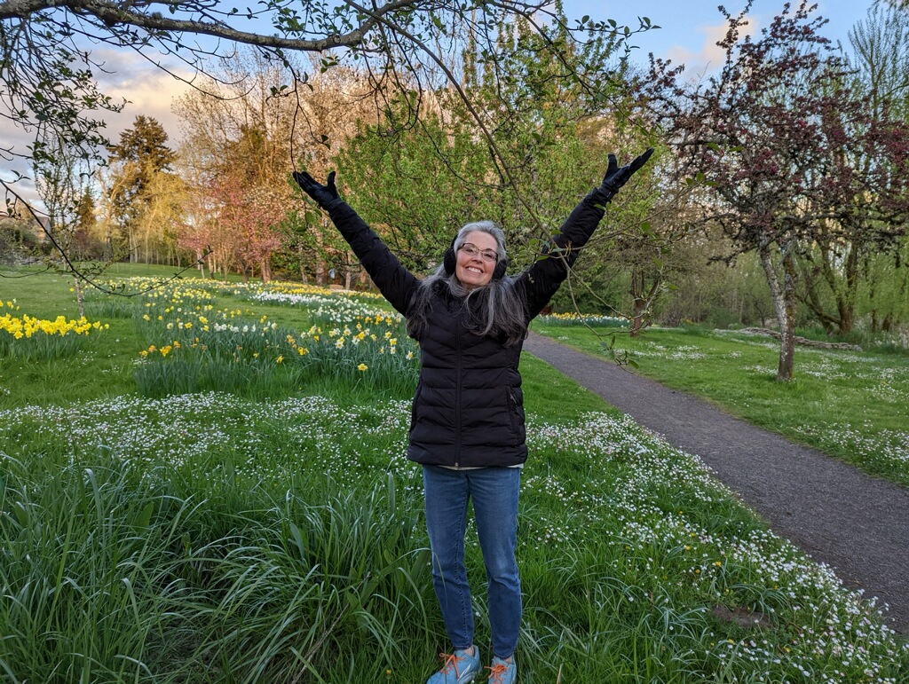 Cindy with her hands lifted in praise in a flower field